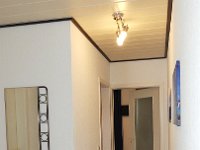 010  Am Ende des Flures befindet sich das Schlafzimmer, links davor das Bad. Im Vordergrund Garderobe mit Spiegel.