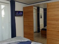 Schlafzimmerschrank mit 3 Schiebetüren  Geräumiger 3-türiger Kleiderschrank mit Ganzkörperspiegel. Über die Tür mit Offen- und Kippfunktion gelangen Sie in den Innenhof. Vom Bett aus können Sie bequem Fernsehen schauen